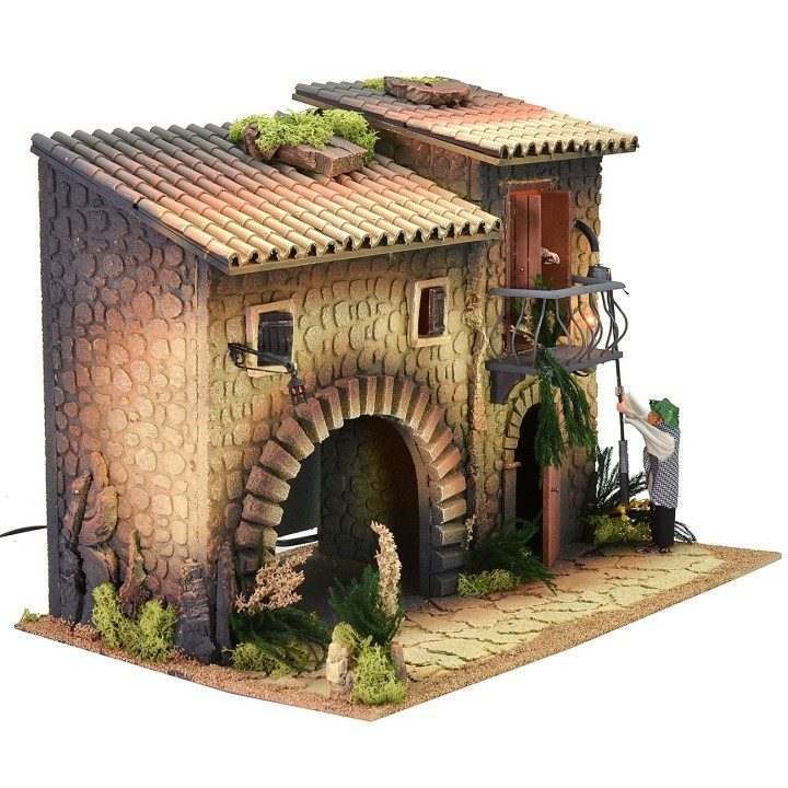 Casa iluminada con farolero de 12 cm en movimiento y mujer que