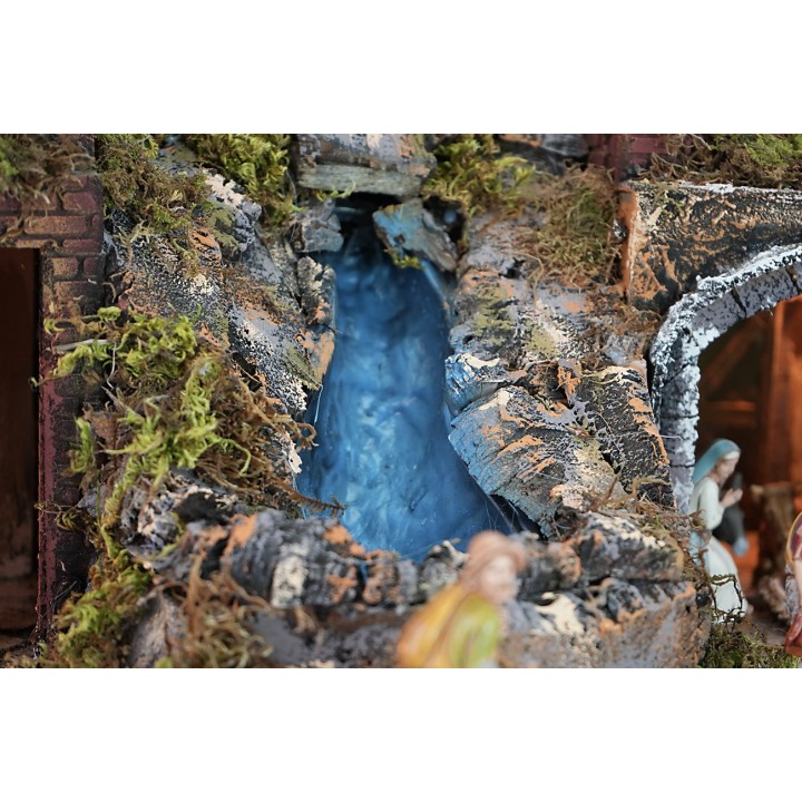 Illuminated nativity scene complete with statues, waterfall