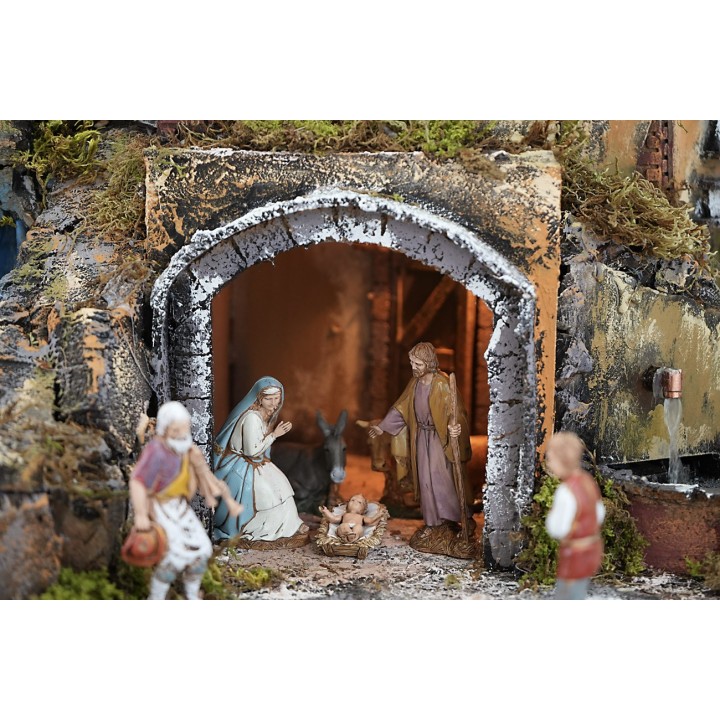 Illuminated nativity scene complete with statues, waterfall