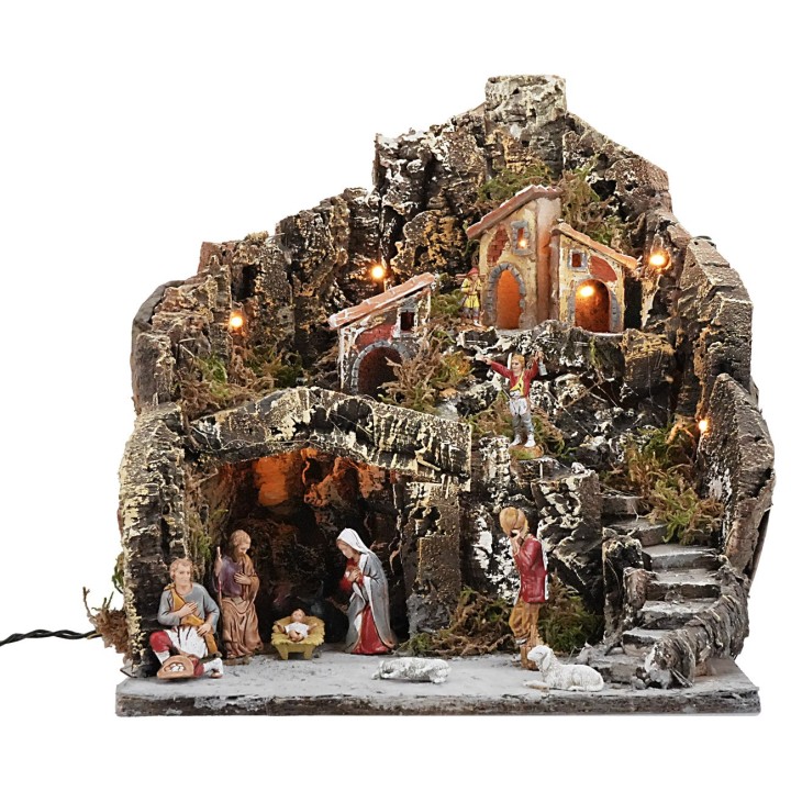 Illuminated nativity scene with village on a mountain complete