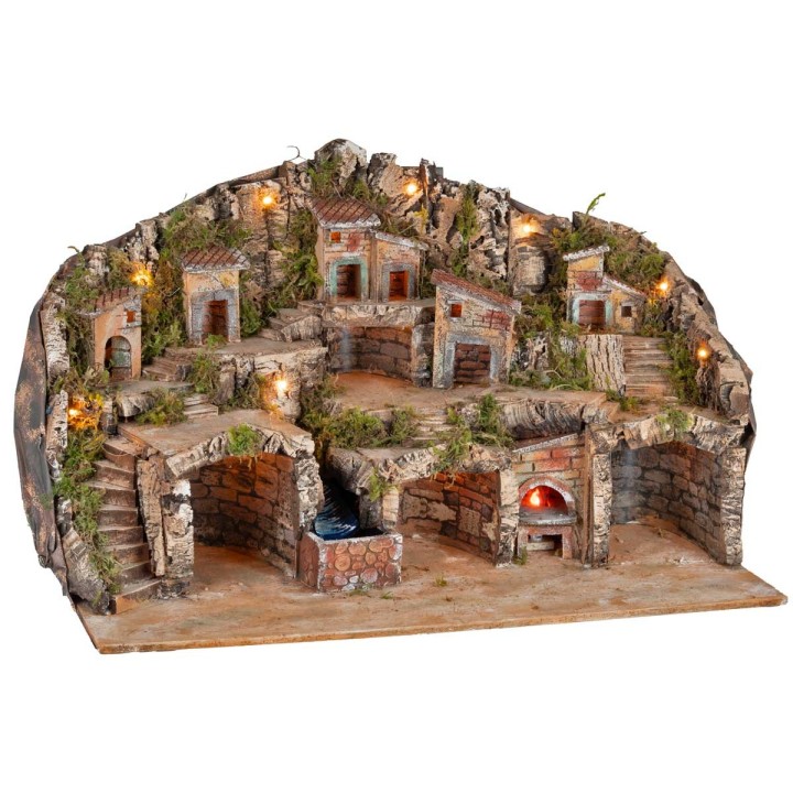 Belén iluminado con cuevas, casitas, arroyo y horno en