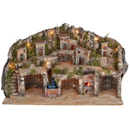 Illuminated nativity scene with caves, little houses, stream