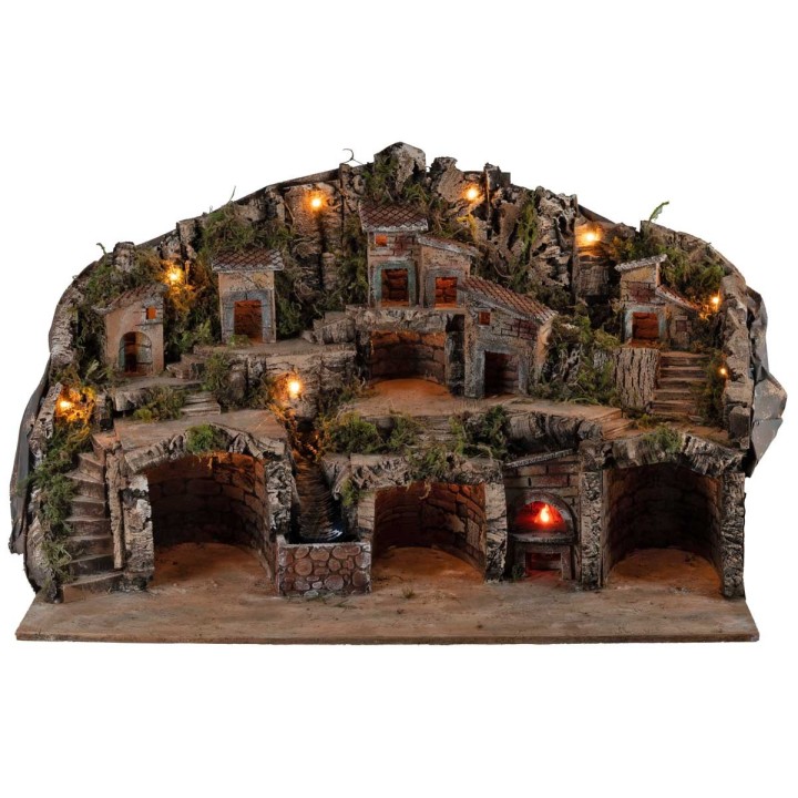 Belén iluminado con cuevas, casitas, arroyo y horno en