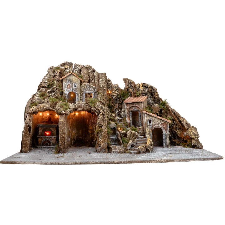 Illuminated nativity scene with oven and small waterfall