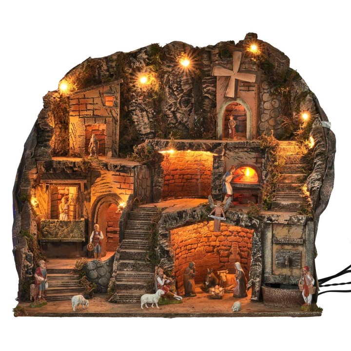 Presepe illuminato con statue, fontana, fuoco e mulino a vento