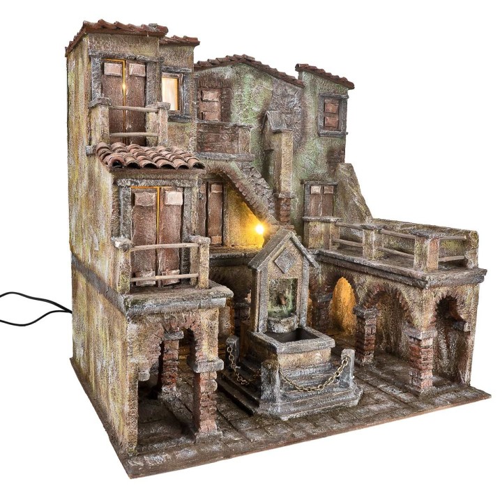 Village with illuminated square and fountain with a pump