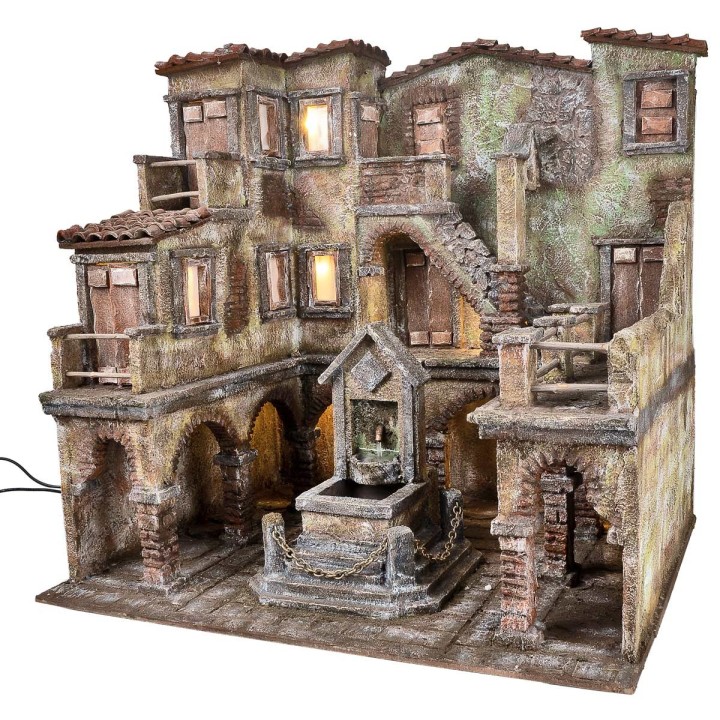 Village with illuminated square and fountain with a pump