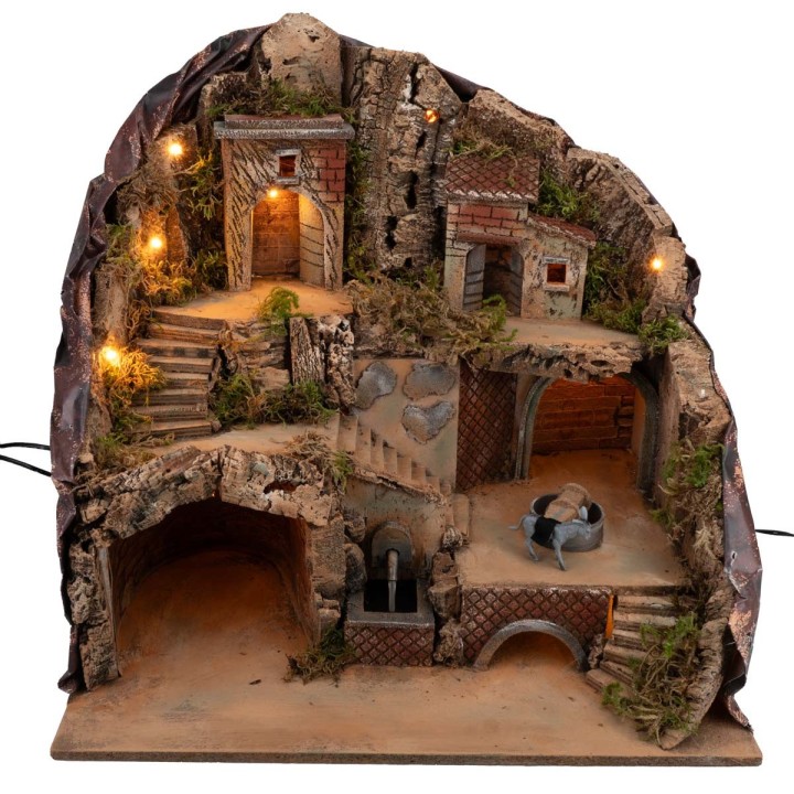 Illuminated nativity scene with fountain and moving donkey at