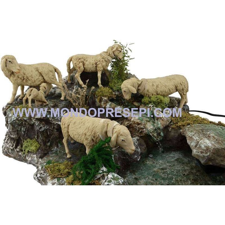 Grupo de ovejas en movimiento con arroyo